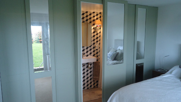 Sliding doors on an integrated En-Suite Shower room and wardrobe combination.