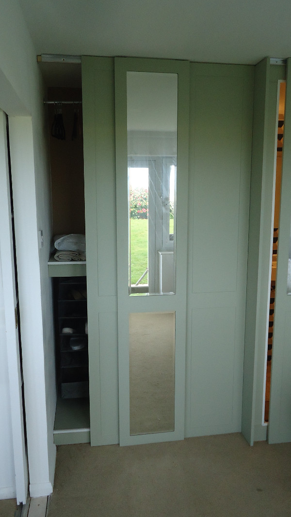 Sliding doors on an integrated En-Suite Shower room and wardrobe combination.